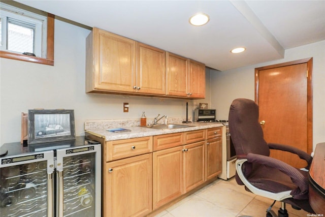 kitchen with wine cooler, gas stove, light tile patterned flooring, and sink