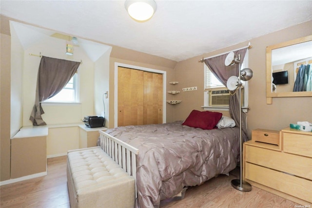 bedroom with hardwood / wood-style flooring, cooling unit, and a closet