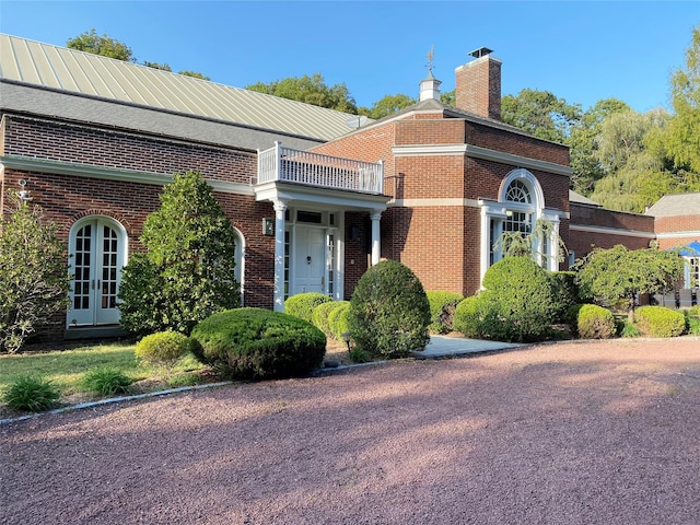 view of home's exterior featuring a balcony and french doors