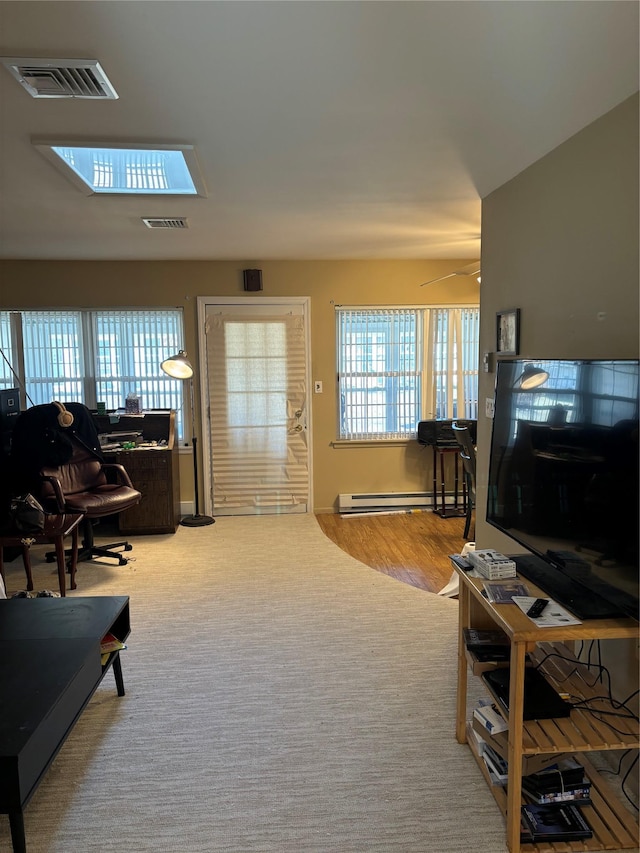 carpeted living room with a baseboard heating unit and ceiling fan