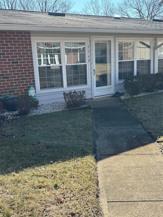 view of exterior entry with a yard