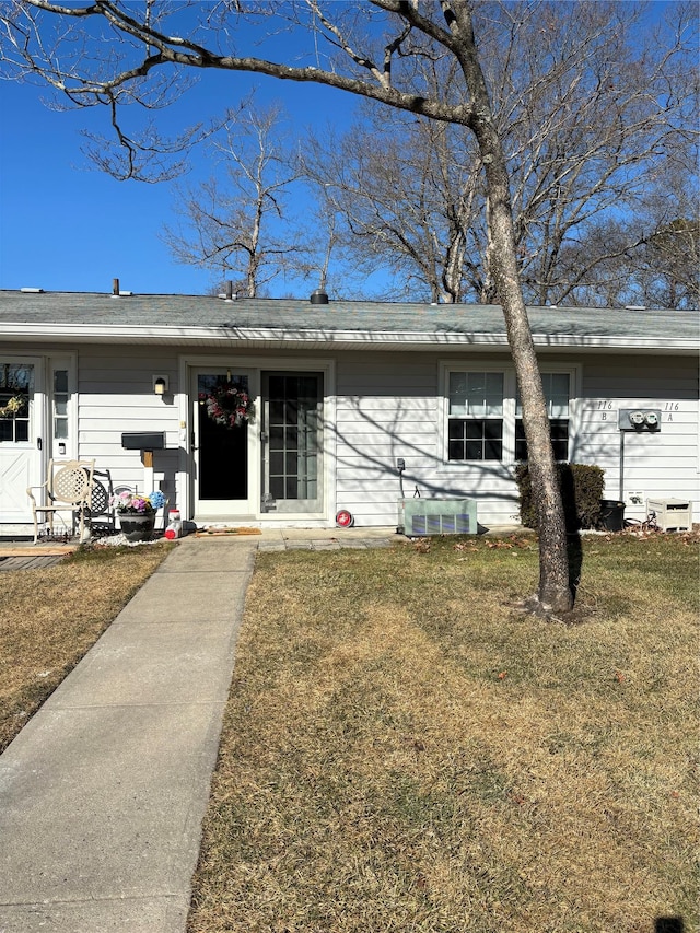 view of front of home with central AC and a front yard