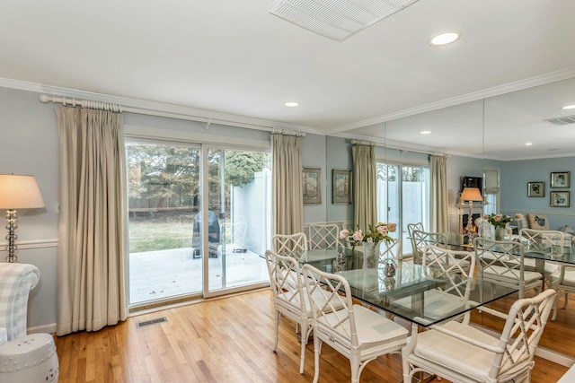 dining room featuring ornamental molding and light hardwood / wood-style flooring