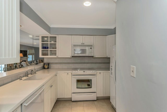 kitchen with light tile patterned flooring, sink, white cabinetry, white appliances, and backsplash