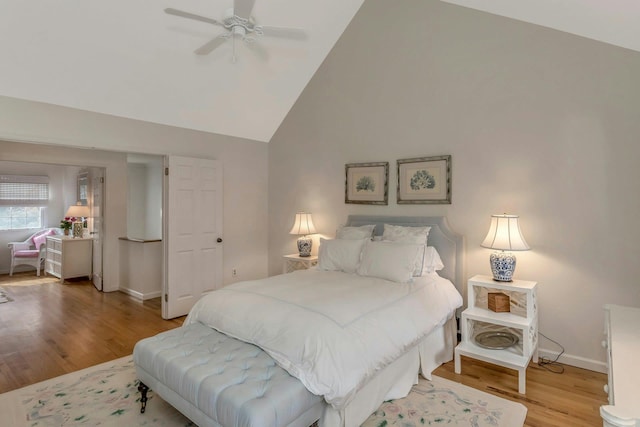 bedroom featuring ceiling fan, high vaulted ceiling, and light wood-type flooring