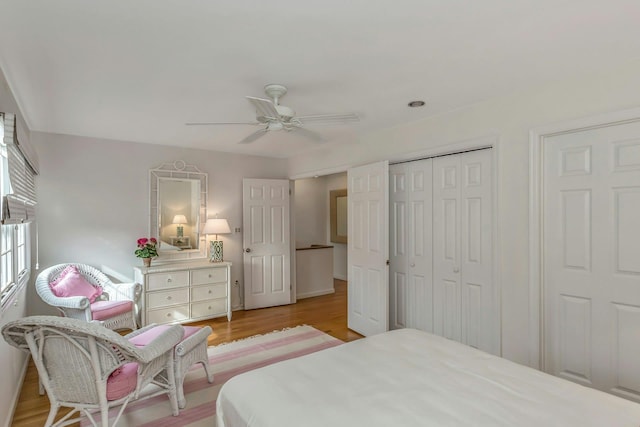 bedroom with ceiling fan, light hardwood / wood-style floors, and a closet