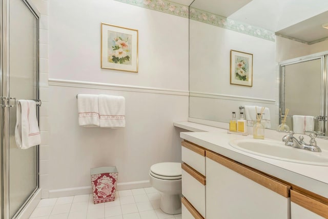 bathroom featuring a shower with door, vanity, tile patterned flooring, and toilet