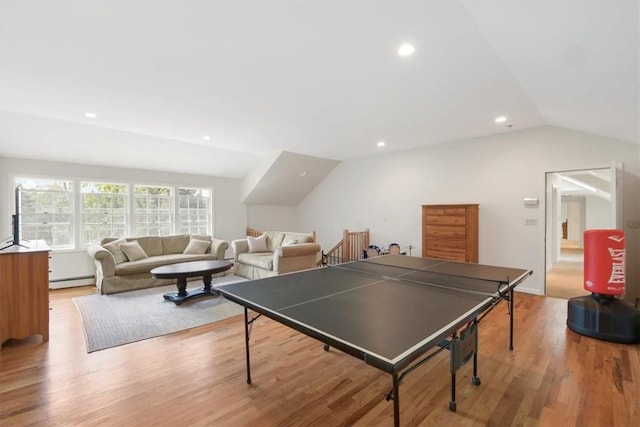 game room featuring light hardwood / wood-style flooring, vaulted ceiling, and baseboard heating