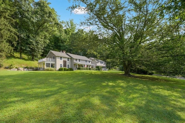 view of front of property with a front yard and a balcony