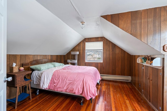 bedroom with lofted ceiling, a baseboard heating unit, dark hardwood / wood-style floors, and wood walls