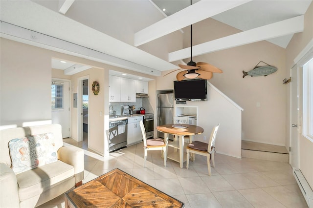 tiled dining area with a baseboard heating unit, vaulted ceiling with beams, sink, and ceiling fan