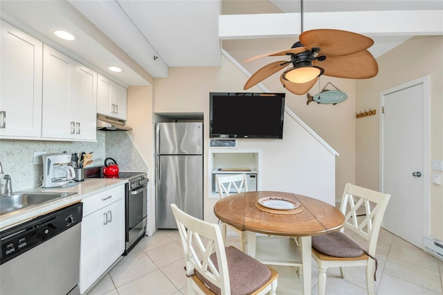 kitchen featuring backsplash, appliances with stainless steel finishes, light tile patterned floors, and white cabinets