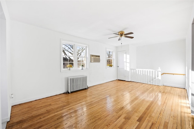 unfurnished living room featuring ceiling fan, wood-type flooring, and radiator