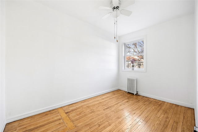 spare room with radiator, light hardwood / wood-style flooring, and ceiling fan