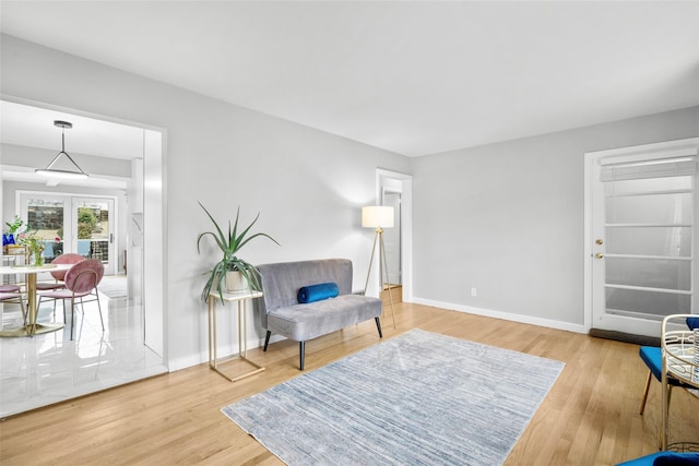 sitting room with french doors, wood finished floors, and baseboards