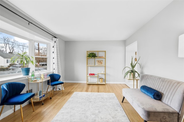 living area with baseboards and wood finished floors