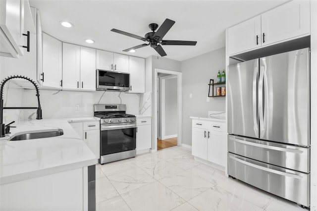 kitchen with stainless steel appliances, marble finish floor, white cabinets, and a sink