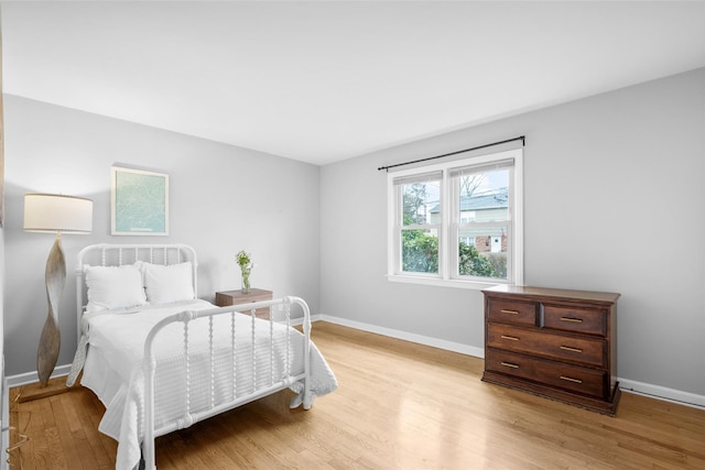 bedroom with light wood finished floors and baseboards