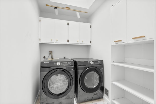 laundry area with cabinet space, washing machine and dryer, and marble finish floor