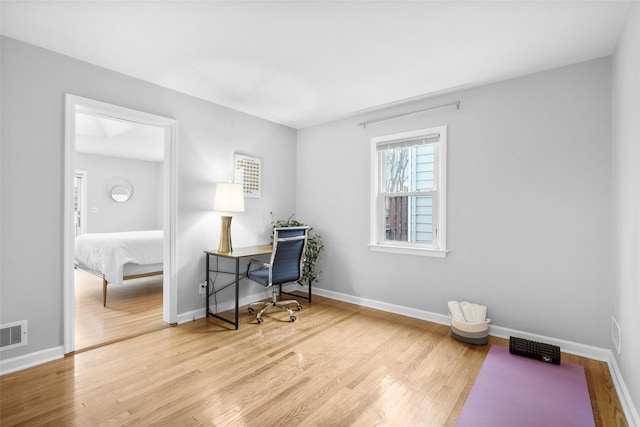 office featuring visible vents, baseboards, and wood finished floors