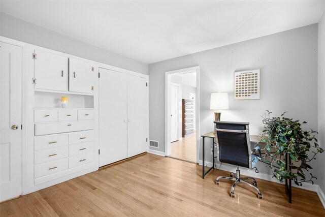 home office featuring baseboards, visible vents, and light wood-style floors