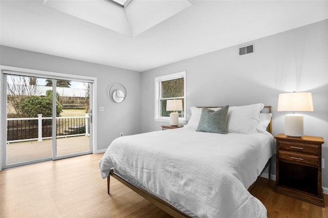 bedroom with access to outside, multiple windows, a skylight, and visible vents