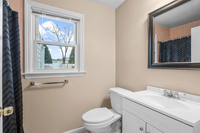 full bath with toilet, baseboards, and vanity