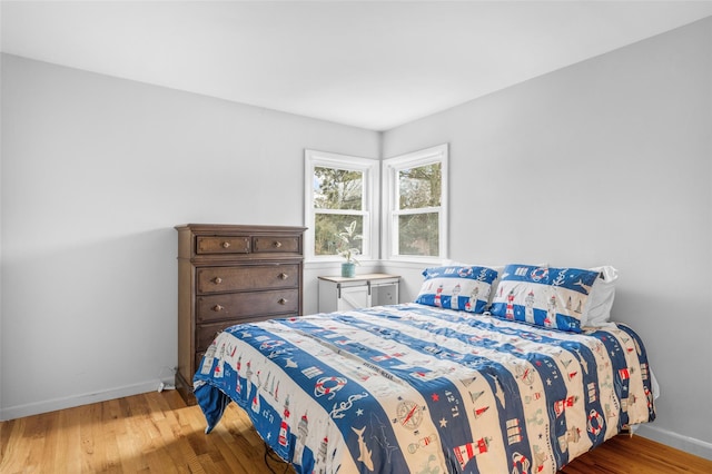 bedroom featuring baseboards and wood finished floors