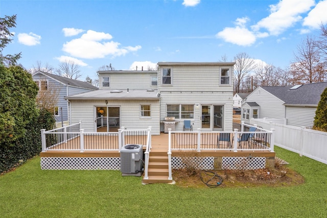 rear view of house with a deck, a yard, central AC unit, and fence