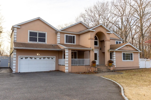 view of front of property featuring aphalt driveway, fence, a garage, and stucco siding