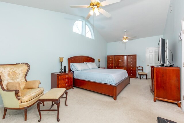 bedroom with lofted ceiling, a ceiling fan, and light colored carpet