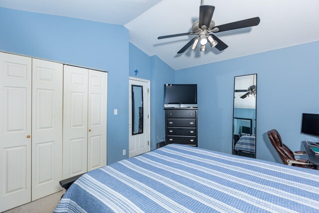 carpeted bedroom featuring ceiling fan, vaulted ceiling, and a closet