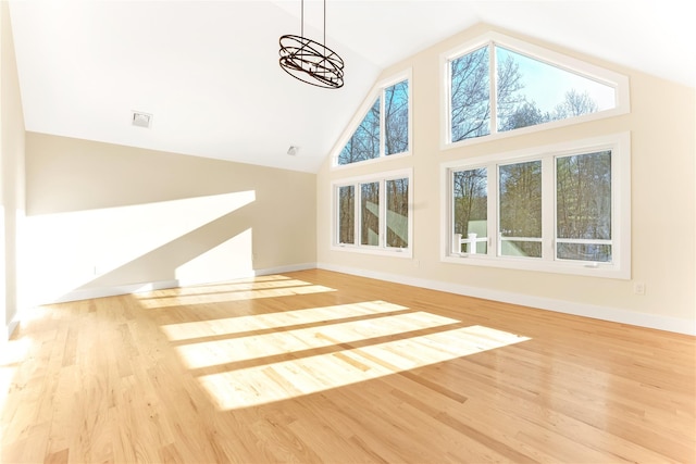 bonus room featuring high vaulted ceiling, light hardwood / wood-style floors, and a notable chandelier