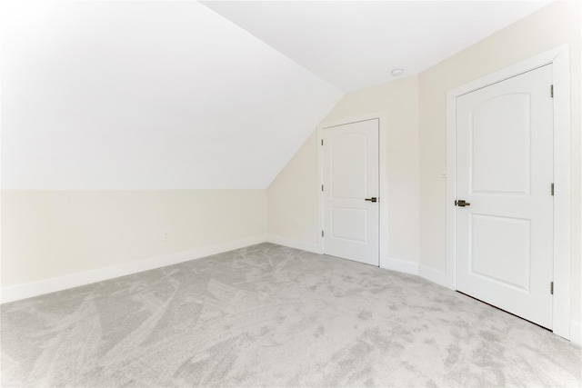 additional living space with vaulted ceiling and light colored carpet