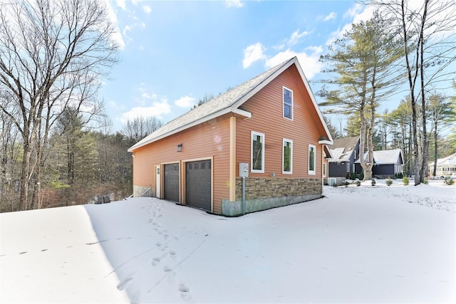 view of snow covered exterior with a garage