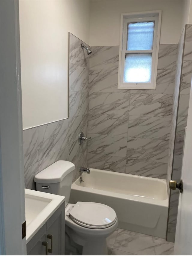 full bathroom with tiled shower / bath combo, vanity, tile walls, and toilet