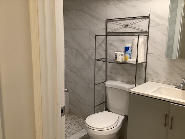 bathroom featuring vanity, tile walls, backsplash, and toilet