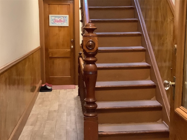 stairway with hardwood / wood-style floors and wood walls