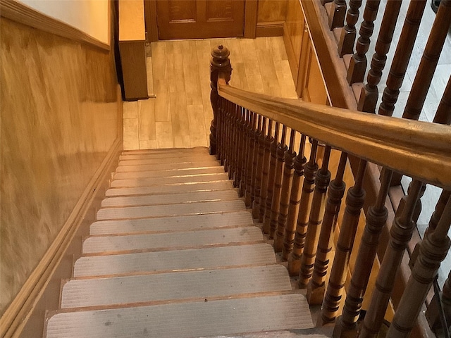 stairway with wood-type flooring and wood walls