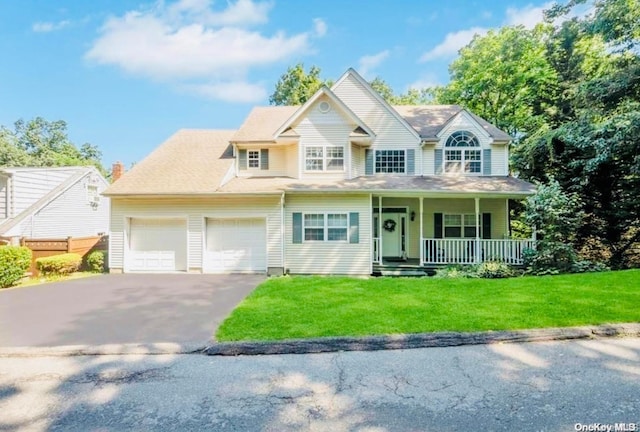 view of front of property featuring a porch, a garage, and a front lawn