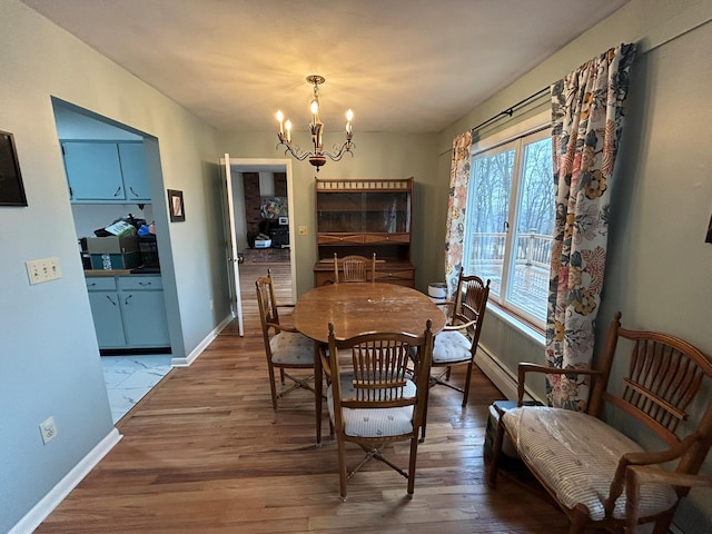 dining area featuring an inviting chandelier, a baseboard radiator, and hardwood / wood-style floors