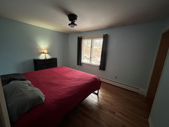 bedroom featuring baseboard heating and hardwood / wood-style floors