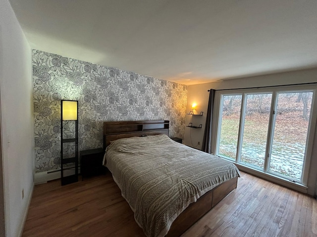 bedroom featuring hardwood / wood-style flooring and a baseboard heating unit