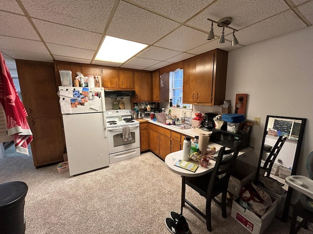 kitchen featuring a drop ceiling and white appliances