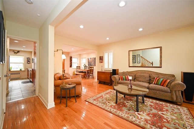 living room with light wood-type flooring, radiator, baseboards, and recessed lighting