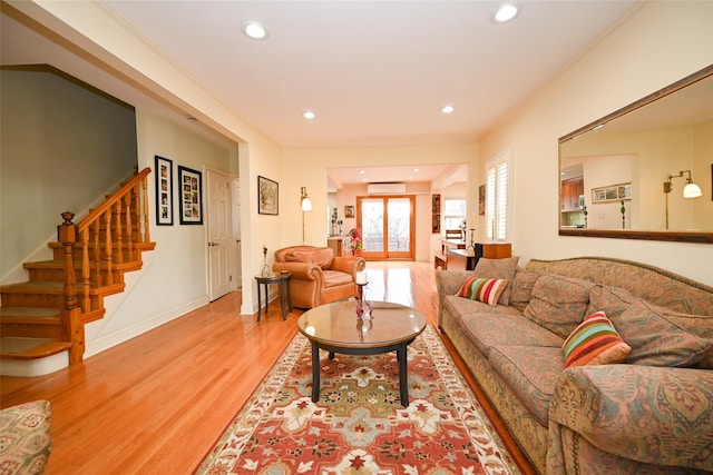 living room featuring recessed lighting, baseboards, light wood finished floors, and stairs