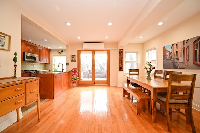 dining room featuring a wall mounted AC, light wood-type flooring, and recessed lighting