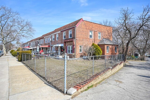 exterior space with a fenced front yard, a residential view, and brick siding