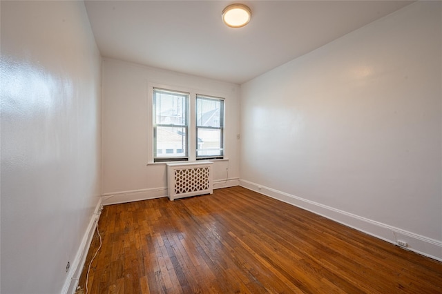 unfurnished room with dark wood-type flooring