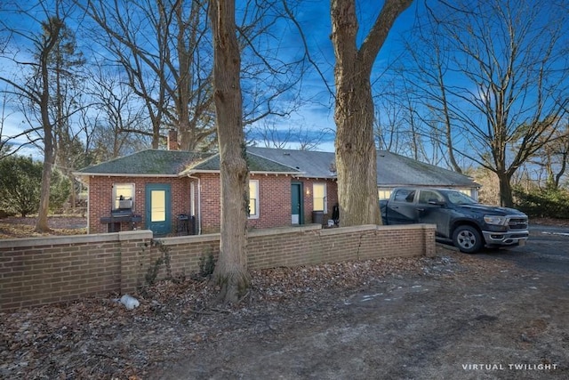 view of front of home featuring a fenced front yard, a chimney, and brick siding